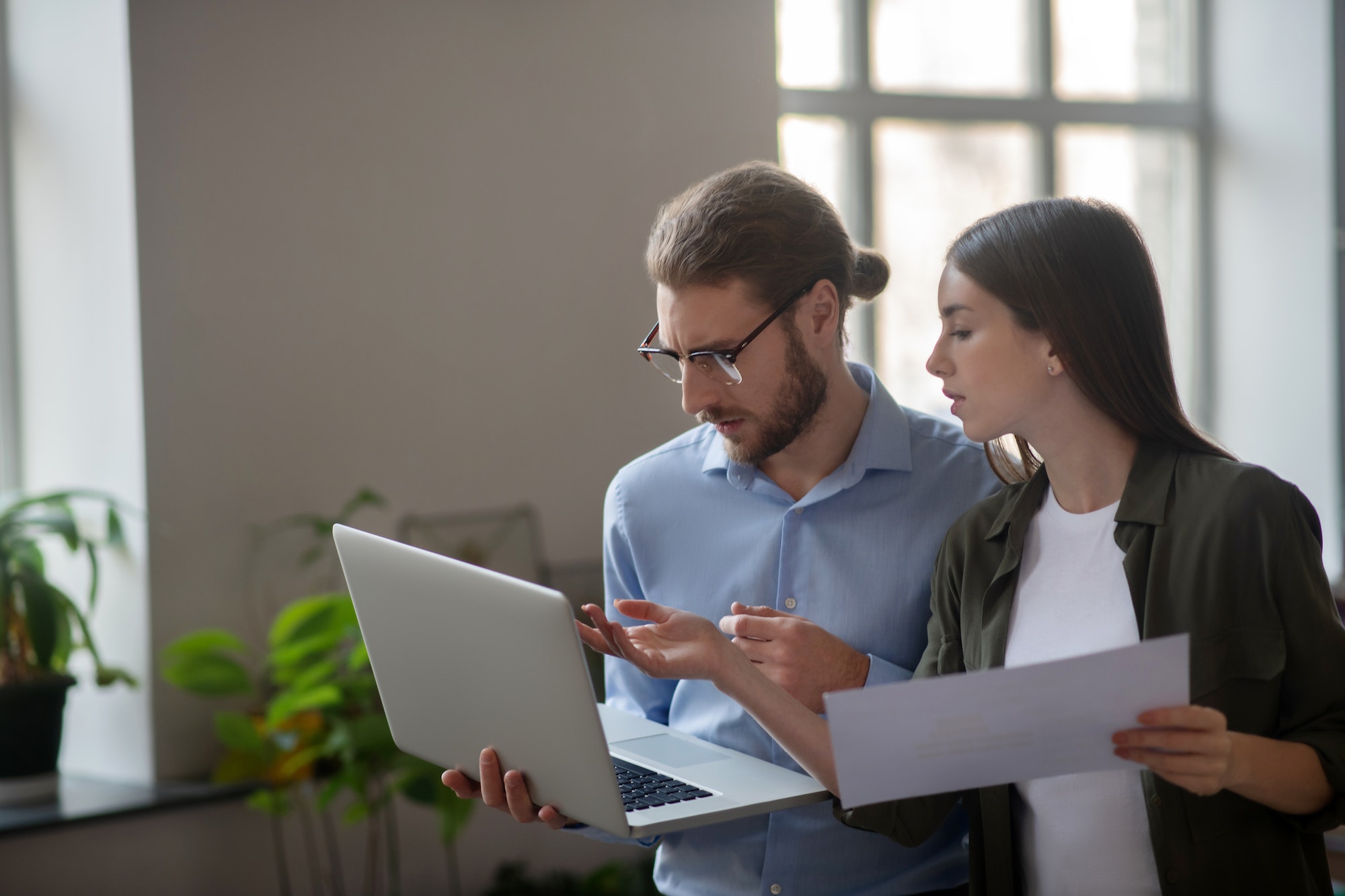 Girl and man with laptop discussing work plan.